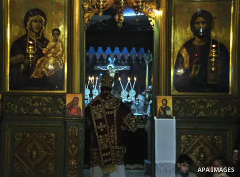 Palestinian Greek Orthodox Christians attend Christmas mass at the Orthodox Saint Porfirios church in Gaza City on January 7, 2014. The Orthodox Church celebrates Christmas and other religious holidays according to the J...