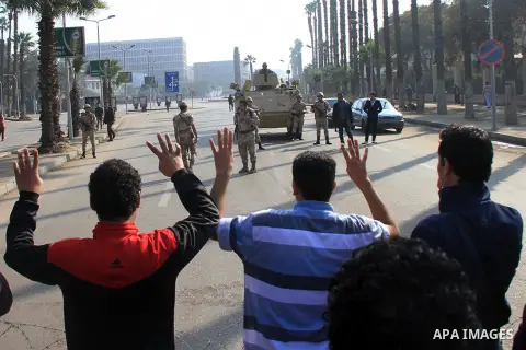 Students of Cairo University, who are supporters of the Muslim Brotherhood and deposed Egyptian President Mohamed Mursi, rise four fingers which has become a symbol of the Rabaah al-Adawiya mosque in front of security fo...