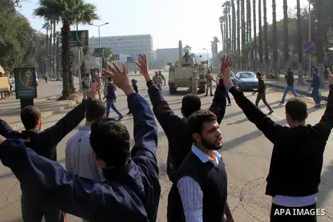 Students of Cairo University, who are supporters of the Muslim Brotherhood and deposed Egyptian President Mohamed Mursi, rise four fingers which has become a symbol of the Rabaah al-Adawiya mosque in front of security fo...