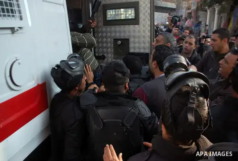Egyptian security forces detain a supporter of the Muslim Brotherhood and ousted Egyptian President Mohamed Mursi, in the El-Omraneya neighborhood in Cairo, Egypt, Friday Jan. 10, 2014. Hundreds of Islamists rallied in E...