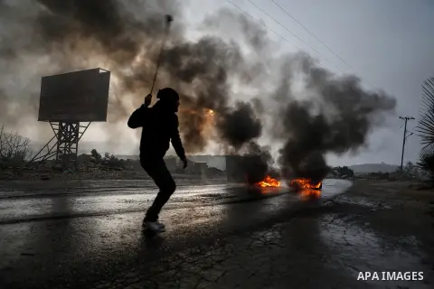 A Palestinian protester throws a stone towards Israeli security forces (unseen) during clashes following a protest of Palestinians against the expansion of the nearby Israeli settlement of Ofra on January 10, 2014 near t...