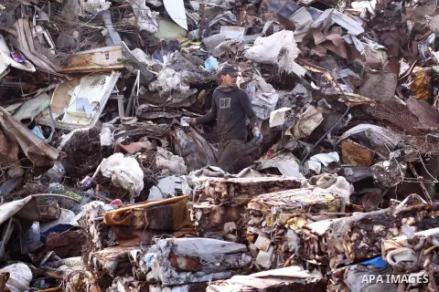 A Palestinian labourer works at workshop for scrap iron compress in Gaza city, on Jan.11, 2014. Israeli authorities stopped importing scraped iron from Gaza strip since 2006 led to pile up over 100.000 tonnes of used iro...