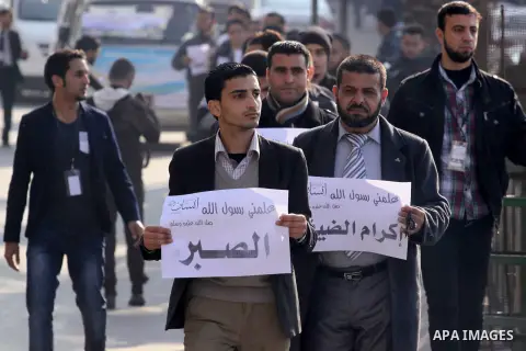 Palestinian youths hold banners as they parade through the streets during a ceremony commemorating the birth of Prophet Mohammed, known in Arabic as "Mawlid al-Nabawi", in Gaza city on Jan. 13, 2014. Muslims celebrate Pr...