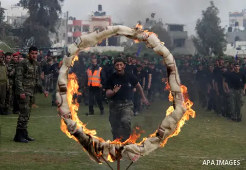 Palestinian students take part in a graduation ceremony for a military-style training programme in Gaza City on January 14, 2014. Some 13,000 students joined the course, which is aimed at preparing them for "liberating P...