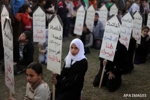 Palestinian children hold placards as they take part in a rally to show solidarity with Palestinian refugees in Syria's main refugee camp Yarmouk, in Deir al-Balah in the central Gaza Strip January 15, 2014. Photo by Ash...