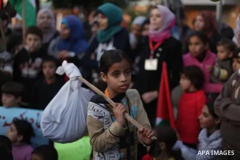 Palestinian children hold placards as they take part in a rally to show solidarity with Palestinian refugees in Syria's main refugee camp Yarmouk, in Deir al-Balah in the central Gaza Strip January 15, 2014. Photo by Ash...