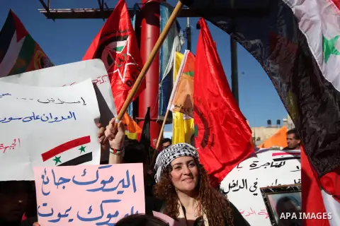 Palestinian protesters wave national and Democratic Front for the Liberation of Palestine flags and hold placards during a demonstration in solidarity with Palestinian refugees in Yarmouk refugee camp in the suburbs of t...