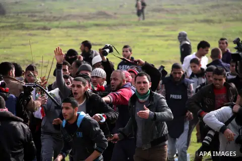 Palestinians carry a fellow protester wounded during clashes with Israeli forces near the Nahal Oz border crossing with Israel, east of Gaza City on January 17, 2014. The Israeli army fired live rounds and tear gas at pr...