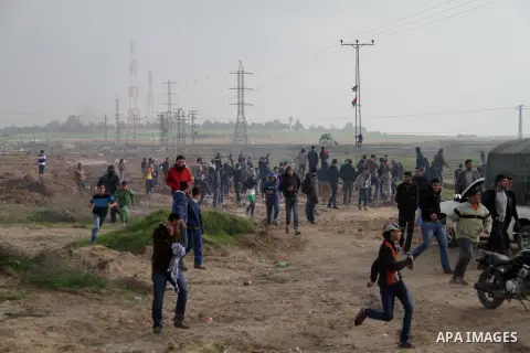 Palestinian protesters take part in a demonstration near the Nahal Oz border crossing with Israel, east of Gaza City on January 17, 2014. The Israeli army fired live rounds and tear gas at protesters near the border fenc...