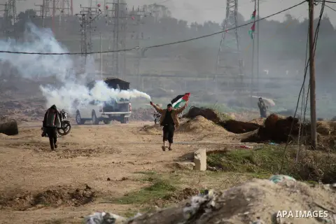 Palestinians throw back tear gas canister during clashes with Israeli forces near the Nahal Oz border crossing with Israel, east of Gaza City on January 17, 2014. The Israeli army fired live rounds and tear gas at protes...