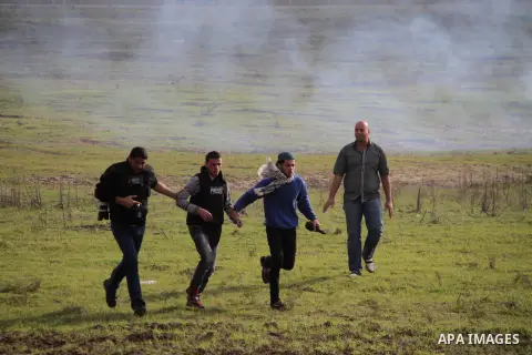Palestinian protesters run away from tear gas fired by Israeli security forces during clashes near the Nahal Oz border crossing with Israel, east of Gaza City on January 17, 2014. The Israeli army fired live rounds and t...