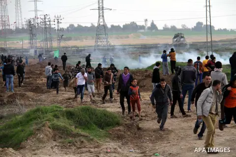 Palestinian protesters run away from tear gas fired by Israeli security forces during clashes near the Nahal Oz border crossing with Israel, east of Gaza City on January 17, 2014. The Israeli army fired live rounds and t...