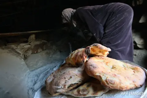 A Palestinian Bedouin woman bakes traditional bread at Khirbet Umm Al-Khair south the West Bank City of Hebron January 21, 2014. Israeli forces raided Umm al-Khair region several times and notified residents of its decis...
