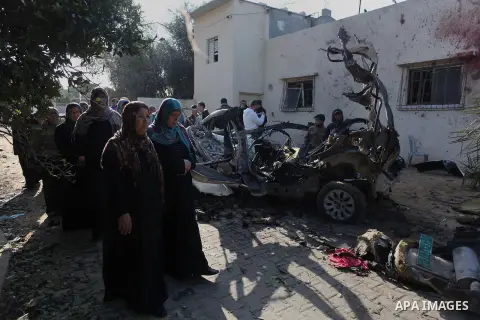 Palestinians gather next to a destroyed car after it was hit by an Israeli air strike in Beit Hanun, northern Gaza Strip, on January 22, 2014, which killed two Palestinian members of Islamic Jihad. Since December 20, six...