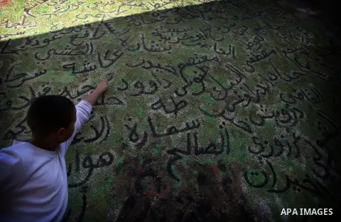 A Palestinian boy points to the names of the residents who left their homes in 1947, in the village of Tarshiha, north Acre on January 21, 2014. Tarshiha was in the territory allotted to the Arab state under the 1947 UN...