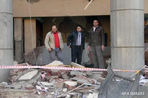 Egyptians inspect the site of a car bomb explosion outside the police headquarters in Cairo on January 24, 2014. A suicide bomber struck Cairo police headquarters in the first of three bombings in the Egyptian capital th...