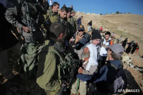 Palestinian Bedouins scuffle with Israeli soldiers in Oum al-Khair village southern West Bank city of Hebron on January 25, 2014. Israeli soldiers prevented the the Bedouin access to pasture on the pretext it closed mili...