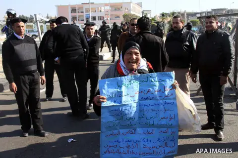 Supporters of Egypt's army chief Field Marshal Abdel Fattah al-Sisi, hold placards during a demonstration outside a police academy on the outskirts of Cairo January 28, 2014, where the trial of ousted Egyptian President...