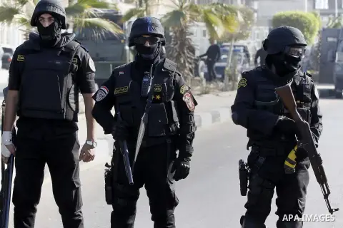 Police and security forces stand guard outside a police academy, where the trial of ousted Egyptian President Mohamed Mursi and members of the Muslim Brotherhood is due to take place, on the outskirts of Cairo, January 2...