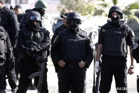Police and security forces stand guard outside a police academy, where the trial of ousted Egyptian President Mohamed Mursi and members of the Muslim Brotherhood is due to take place, on the outskirts of Cairo, January 2...