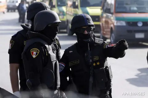 Police and security forces stand guard outside a police academy, where the trial of ousted Egyptian President Mohamed Mursi and members of the Muslim Brotherhood is due to take place, on the outskirts of Cairo, January 2...