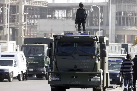 Police and security forces stand guard outside a police academy, where the trial of ousted Egyptian President Mohamed Mursi and members of the Muslim Brotherhood is due to take place, on the outskirts of Cairo, January 2...