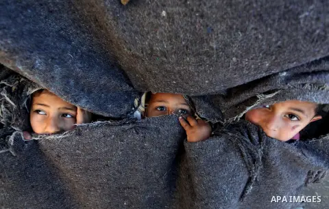 Palestinian children look through a curtain as they play in front their Family's house at al-Shati refugee camp in the west Gaza City January 29, 2014. Photo by Ashraf Amra