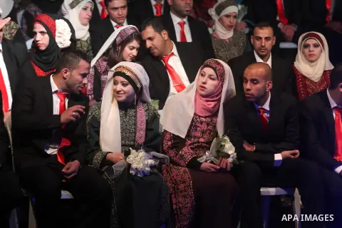 Palestinian couples are pictured on January 28, 2014, during a mass wedding ceremony attended by Palestinian Authority President Mahmud Abbas (unseen) in the West bank city of Jericho. Nearly 300 Palestinians were marrie...