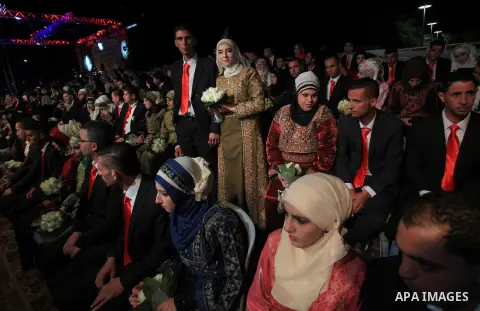 Palestinian couples are pictured on January 28, 2014, during a mass wedding ceremony attended by Palestinian Authority President Mahmud Abbas (unseen) in the West bank city of Jericho. Nearly 300 Palestinians were marrie...