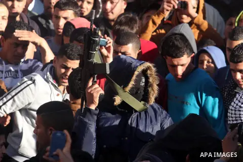 A Palestinian gunman holds his weapon during the funeral of Mohammad Mubarak, 18, in the Jalazoun refugee camp near the West Bank city of Ramallah, Wednesday, Jan. 29, 2014. Israeli troops shot Mubarak to death on Wednes...