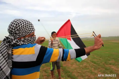 Palestinian protesters hurl stones at Israeli forces during clashes near the border with Israel, east of Jabalia refugee camp in northern Gaza Strip on January 31, 2014. The Israeli army fired live rounds and tear gas at...