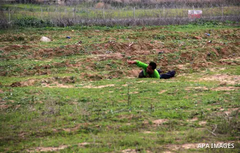 A Palestinian protester takes cover during clashes with Israeli forces near the border with Israel, east of Jabalia refugee camp in northern Gaza Strip on January 31, 2014. The Israeli army fired live rounds and tear gas...