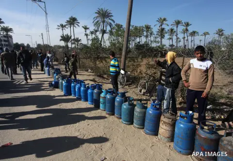 Palestinians wait in line to refill cooking gas bottles at a warehouse in Deir al-Balah center Gaza Strip on Feb. 01, 2014. Photo by Ashraf Amra