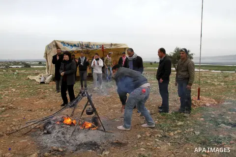 Palestinian activists gather around a fire in the Jordan Valley near the West Bank village of Bardala, 02 February 2014. Palestinian and international activists erected a new protest encampment called 'al-Awda,' or 'Retu...