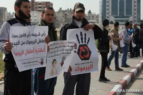 Palestinian youths take part in a protest to show solidarity with Palestinian refugees Syria's main refugee camp Yarmouk, in Gaza City on Feb. 04, 2014. Photo by Ashraf Amra