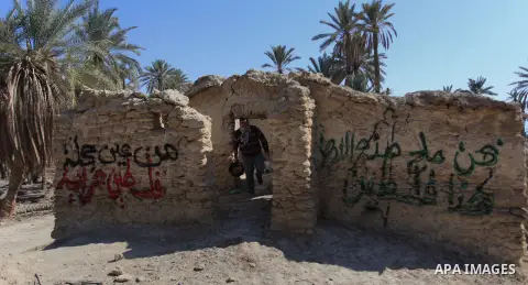 A Palestinian activist stands near a wall during a protest in the old village of Ein Hijleh in the Jordan Valley, in a palm plantation near the West Bank city of Jericho, 05 February 2014. The protest is aimed against th...