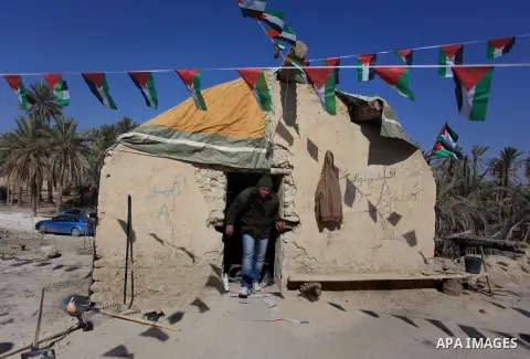 A Palestinian activist stands near a tent during a protest in the old village of Ein Hijleh in the Jordan Valley, in a palm plantation near the West Bank city of Jericho, 05 February 2014. The protest is aimed against th...