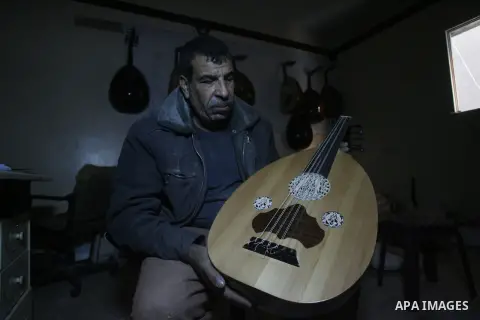 Hammad Atwa, a Palestinian man who makes lutes, known in Arabic as an "Oud" shows one of his handmade musical instruments at the Khan Younis refugee camp in the southern Gaza Strip on February 19, 2014. Hammad sells his...