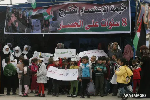 Palestinians hold banners during a protest in front of the Rafah border crossing with Egypt in the southern Gaza Strip on February 24, 2014, to demand that Egypt lift border crossing restrictions. Egypt imposed the restr...