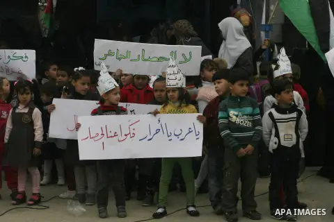 Palestinians hold banners during a protest in front of the Rafah border crossing with Egypt in the southern Gaza Strip on February 24, 2014, to demand that Egypt lift border crossing restrictions. Egypt imposed the restr...