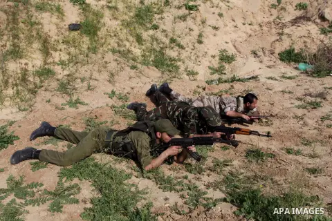 A photo taken on Feb. 23, 2014 shows Palestinian actors dressed as Hamas militants aiming their guns during filming in a movie being made in Gaza called, ''Losing Shalit," in Gaza City. "Losing Schalit," currently being...