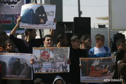 Palestinians hold banners during a protest in front of the Rafah border crossing with Egypt in the southern Gaza Strip on February 24, 2014. to demand that Egypt lift border crossing restrictions. Egypt imposed the restr...