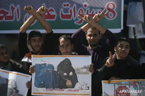 Palestinians hold banners during a protest in front of the Rafah border crossing with Egypt in the southern Gaza Strip on February 24, 2014. to demand that Egypt lift border crossing restrictions. Egypt imposed the restr...