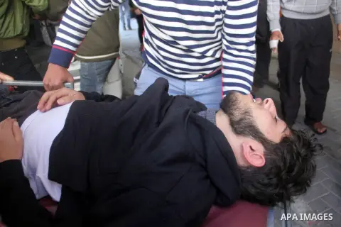 Palestinian medics wheel an injured man at a hospital after he wounded during clashes with Israeli security forces near Nahal Oz border crossing with Israel, east of Gaza City, on February 25, 2014 following a demonstrat...