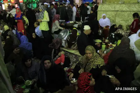 Egyptians eat rice and meats to worshippers after El Ishaa prayers at the Al-Hussein mosque, during celebration day of "Moulid Al-Hussein" the birthday of Prophet Mohammad's grandson Hussein in Cairo, February 25, 2014....