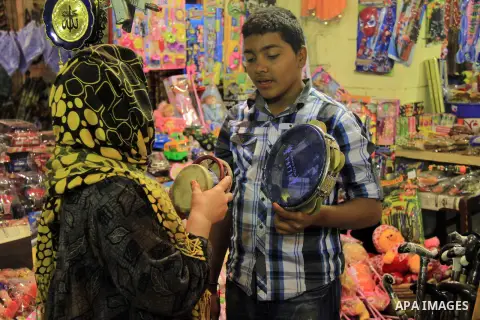 A Egyptian man sells a handicraft to worshippers after El Ishaa prayers at the Al-Hussein mosque, during celebration day of "Moulid Al-Hussein" the birthday of Prophet Mohammad's grandson Hussein in Cairo, February 25, 2...