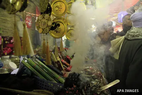 A Egyptian man sells copper works to worshippers after El Ishaa prayers at the Al-Hussein mosque, during celebration day of "Moulid Al-Hussein" the birthday of Prophet Mohammad's grandson Hussein in Cairo, February 25, 2...