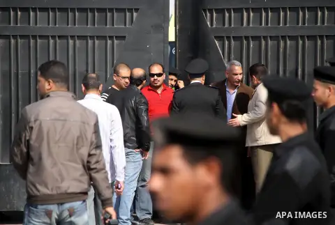 Egyptian security stand guard as ambulances drive out of Cairo international airport on February 26, 2014, carrying the bodies of seven Egyptian victims who were found shot dead in Jalluta, near Benghazi in eastern Libya...