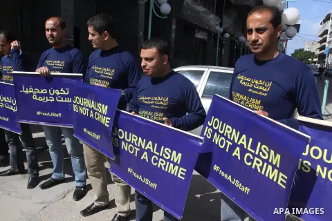 Palestinian journalists hold placards during a protest in support of the Al-Jazeera staff, who have been detained by Egyptian authorities since last year, in Gaza city, Feb. 27, 2014. Qatar-based Al Jazeera TV network ha...