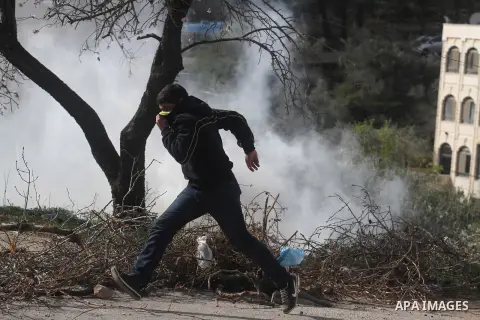 A Palestinian youth throws stones at Israeli soldiers during clashes in the West Bank village of Birzeit, near Ramallah February 27, 2014. The clashes broke out after Israeli forces opened fire and killed a Palestinian t...